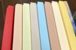 Acht ZeitFächer in Rot, Nude, Hellgrün, Grau, Hellblau, Taupe, Creme und Gelb nebeneinander