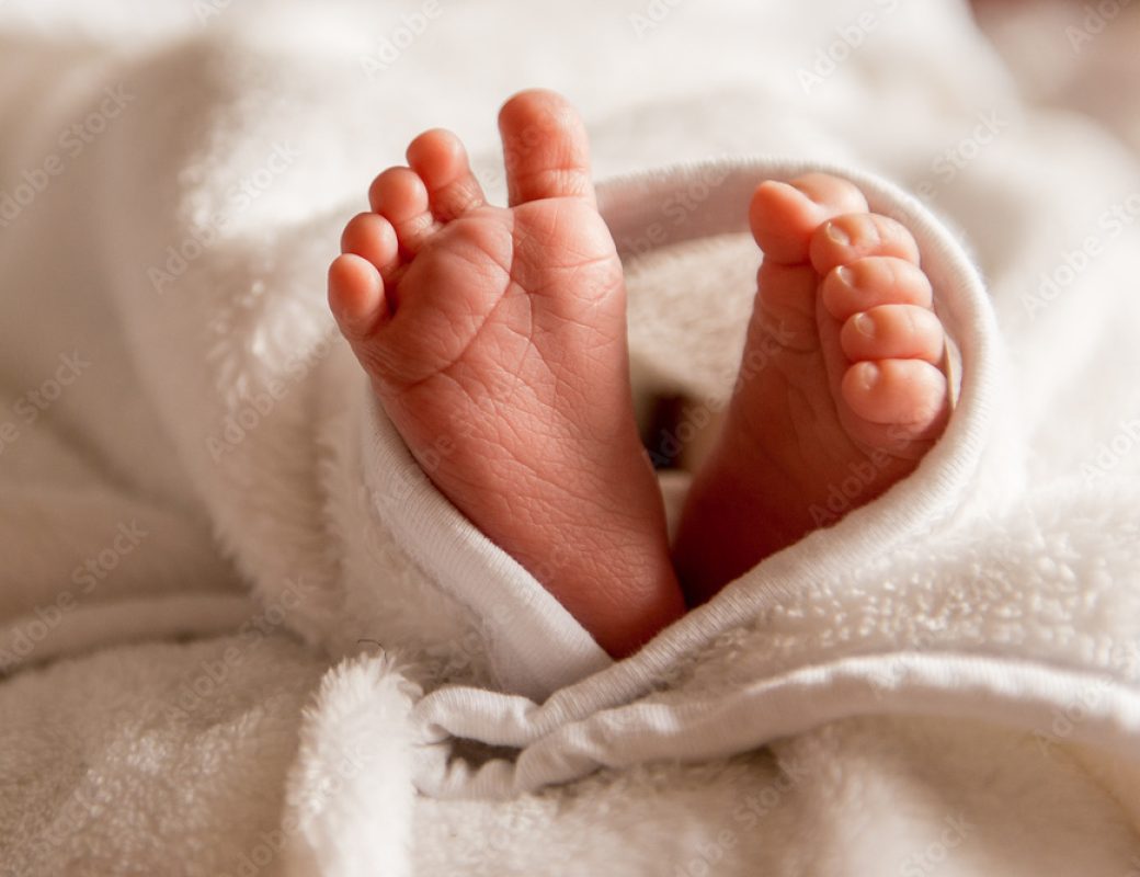Babyfüße in einer weißen Decke